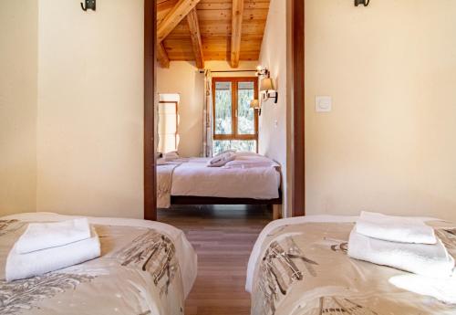 two beds in a room with a mirror at Chalet Hotel La Tarine in Peisey-Nancroix