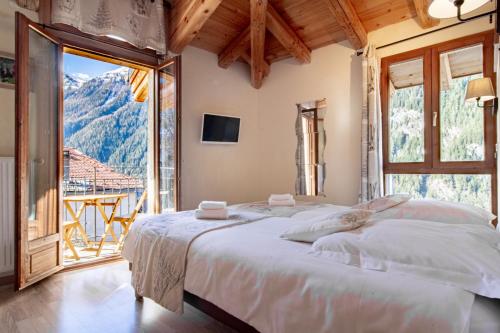 a bedroom with two beds and a large window at Chalet Hotel La Tarine in Peisey-Nancroix