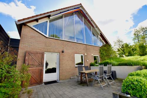a glass house with a table and chairs on a patio at Resort De Vlasschure in Wissenkerke