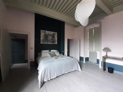 um quarto com uma cama branca num quarto em Maison du Chevalier des Huttes - Table et Chambres d'hôtes em Vic-sur-Cère