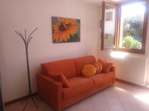 a living room with an orange couch with a teddy bear on it at Oltre il Poggio del Sole in Marostica