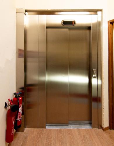 a metal elevator in a room with a fire extinguisher at Chalet Hotel La Tarine in Peisey-Nancroix