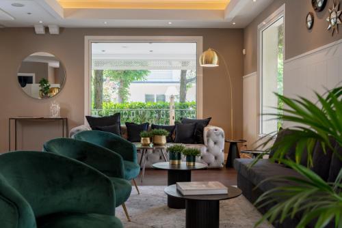 a living room with green furniture and a large window at Hotel Maestrale in Riccione