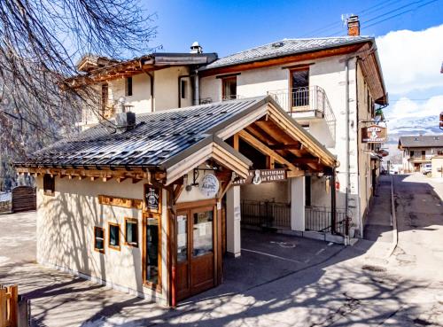 a building with a wooden roof on a street at Chalet Hotel La Tarine in Peisey-Nancroix