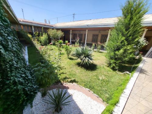 a garden in front of a house with plants at Hotel Motrid in Samarkand