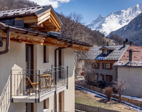 a building with a balcony with a view of a mountain at Chalet Hotel La Tarine in Peisey-Nancroix