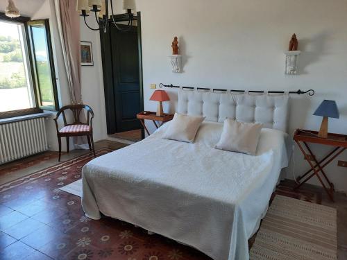 a bedroom with a large white bed and a chair at Casa Fossello in Montabone