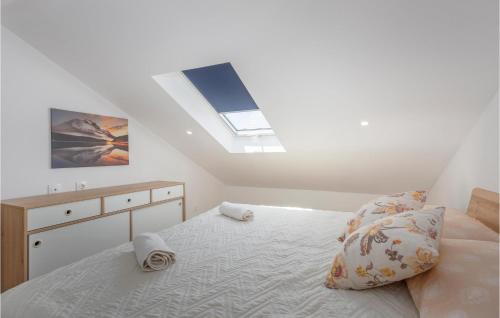 a white bedroom with a bed and a skylight at Nice Apartment In Rijeka With House Sea View in Rijeka