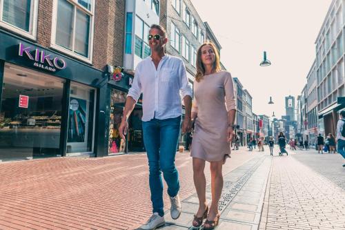 a man and a woman walking down a street at EuroParcs De Kraaijenbergse Plassen in Groot-Linden