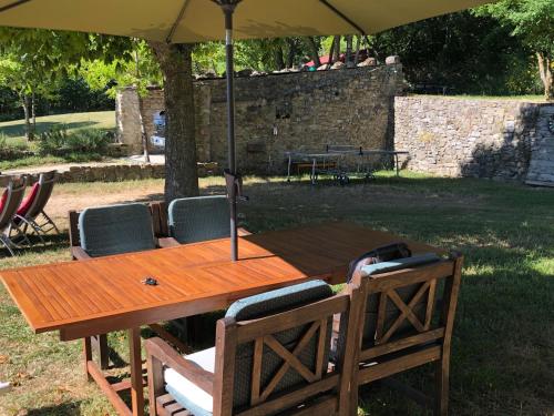a wooden table and chairs under an umbrella at Weekend en Provence in Comps