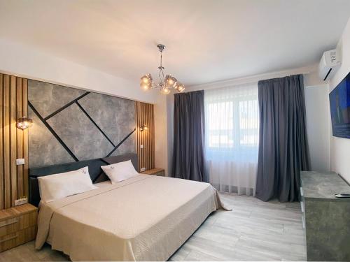 a bedroom with a bed and a large window at Ada Luxury Apartments 57 in Mamaia