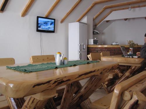 a dining room with a wooden table and a laptop at Casa Felicia in Moieciu de Jos