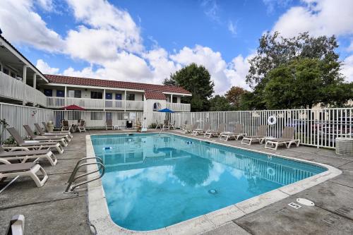 a swimming pool with chairs and a fence at Super 8 by Wyndham Petaluma in Petaluma