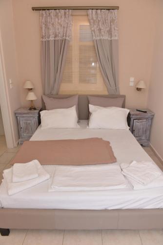 a large white bed in a bedroom with a window at Papikinou Studios in Adamantas