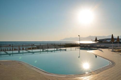 een zwembad met de oceaan op de achtergrond bij Blu Hotel in Pontecagnano