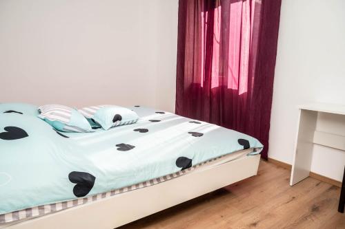 a bedroom with a white bed with black pillows at Apartment Marta in Raša