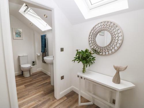 łazienka z umywalką i lustrem na ścianie w obiekcie 15 Parc Delfryn w mieście Brynteg