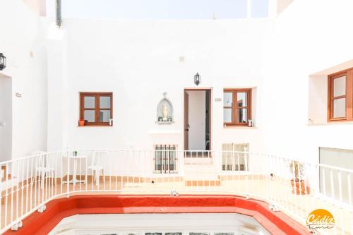 een wit gebouw met een balkon en een zwembad bij Casa Rehala by Cadiz Time in Cádiz