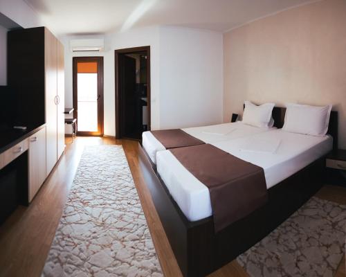 una camera con un grande letto e una televisione di Delta Est Hotel & Restaurant a Sulina