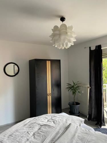 a bedroom with a bed and a chandelier at City Apartment #2 bei der Porzellan Manufaktur in Meißen