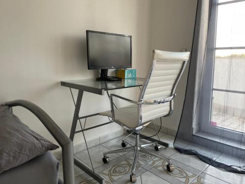 a desk with a television and a chair in a room at Parkplätze, Einzelbetten, 2 Balkone, fast Wi-Fi 100 Mbit, Homeoffice, Aufzug, lichtdurchflutet, Panoramablick in Erlensee
