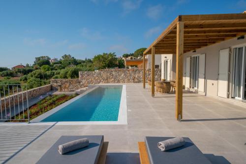 a villa with a swimming pool and a house at Summer Breeze Villa in Tzamarelláta