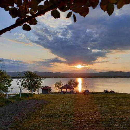 KnićにあるRustic House Radovicのガゼボ付きの湖上の夕日