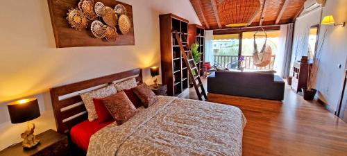 - une chambre avec un lit et un canapé rouge dans l'établissement CASA BALIMAR, à Tarajalejo