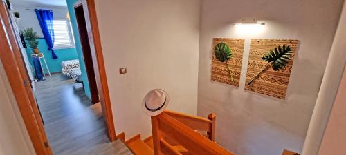 a hallway with a staircase with a light and a wall with paintings at CASA BALIMAR in Tarajalejo