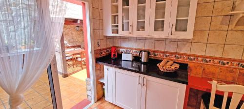 a kitchen with white cabinets and a black counter top at CASA BALIMAR in Tarajalejo