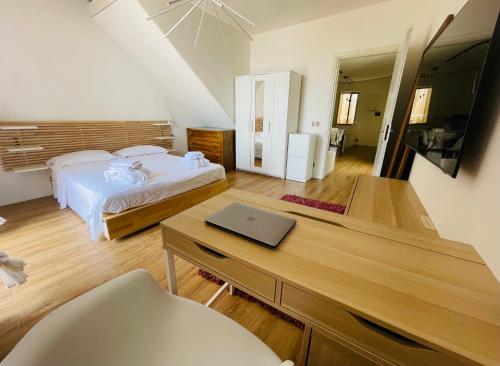 Sdraiati Apartments - Bed & Breakfast - Pollica في بولّيكا: غرفة نوم مع سرير ومكتب مع الكمبيوتر المحمول