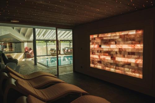 a living room with chairs and a swimming pool at Les Gentianettes Hotel & Spa in La Chapelle-dʼAbondance