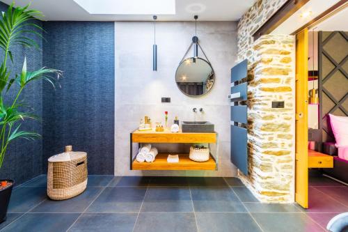 a bathroom with a sink and a stone wall at Nuit confort avec Balnéo XXL privative et Climatisation in Nantes