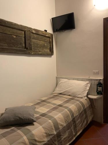 - une chambre avec un lit et une télévision murale dans l'établissement Enjoy Ledro B&B, à Ledro