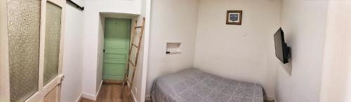 Habitación pequeña con cama y pasillo en Joli logement centre ville avec clim en Orange