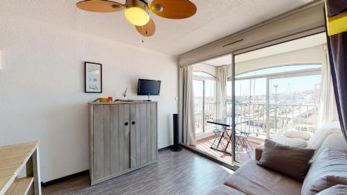 Il comprend un salon avec un canapé, une télévision et un balcon. dans l'établissement Studio avec belle vue sur le port, au Cap d'Agde
