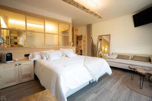 a bedroom with a large white bed and a couch at Hotel Don Marcos in Osma