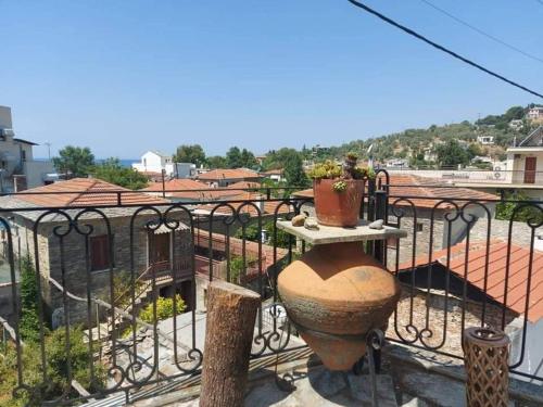 a balcony with a fence and a pot on a table at Το Πέτρινο Αρχοντικό in Afissos