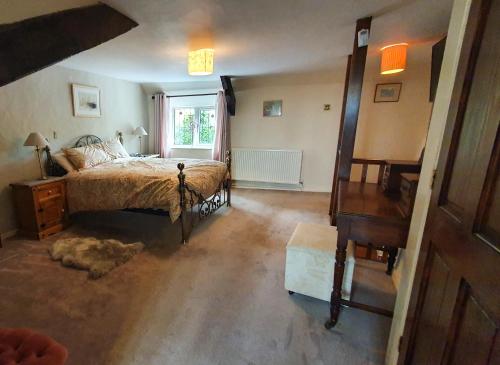 惠靈頓的住宿－Magnolia Cottage，一间卧室配有一张床、一张书桌和一个窗户。