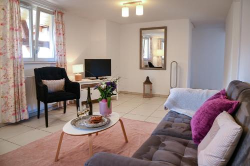 un salon avec un canapé et une table dans l'établissement Le Hameau d'Eguisheim - Chambres d'hôtes & Gîtes, à Eguisheim