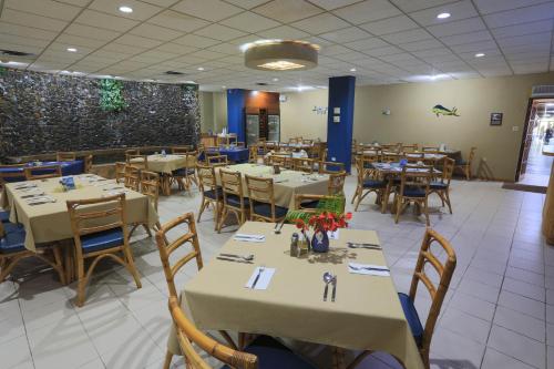 un comedor con mesas y sillas en un restaurante en Parador Boquemar, en Boquerón