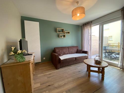 un salon avec un canapé et une table dans l'établissement Nature - Gîte entièrement neuf à 100m de la plage, à Wimereux