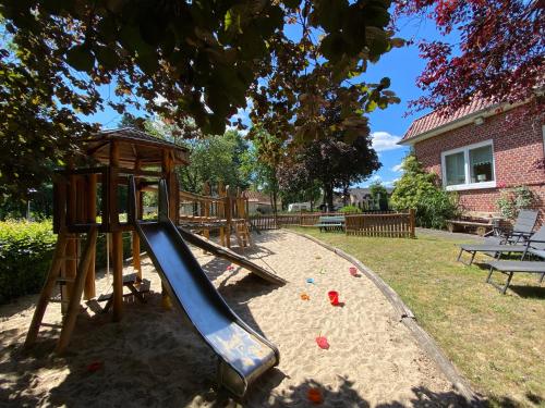 a playground with a slide in a yard at Neumanns Waldschänke in Soltau