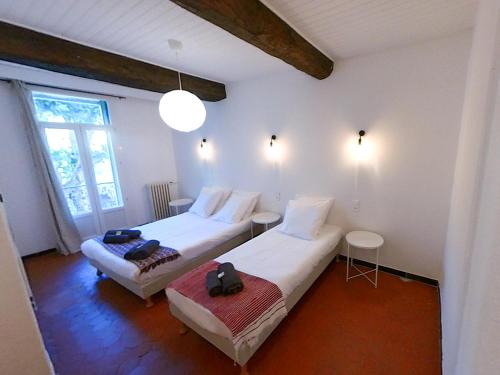 a bedroom with two beds and two tables in it at LA CASA DINA in Banyuls-sur-Mer