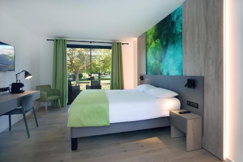 a bedroom with a bed and a desk and a window at Logis Hôtel & Spa Déjeunez Sous L'Arbre in Rousset