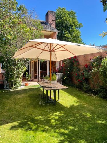 una mesa de picnic con una sombrilla en un patio en wohnliches , behagliches Zimmer mit Balkon und wifi, en Mönchengladbach