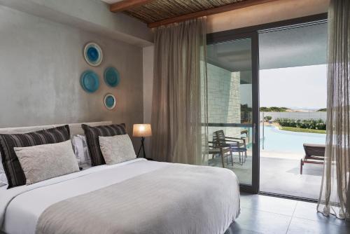 a bedroom with a large bed and a balcony at Atlantica Dreams Resort in Gennadi