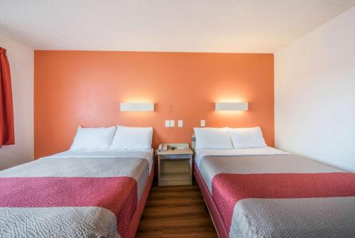 two beds in a room with orange walls at Motel 6-Fairfield, CA - North in Fairfield