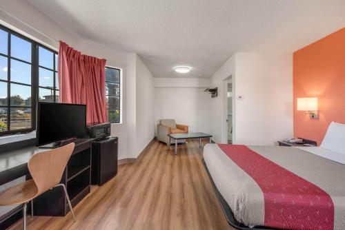 a hotel room with a bed and a flat screen tv at Motel 6-Fairfield, CA - North in Fairfield