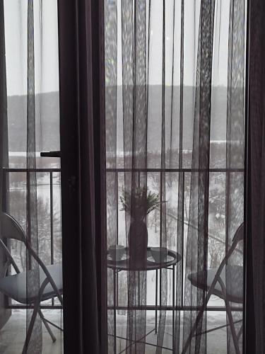 a table with a vase on it in a window at Kechi Apart 266 in Tsaghkadzor